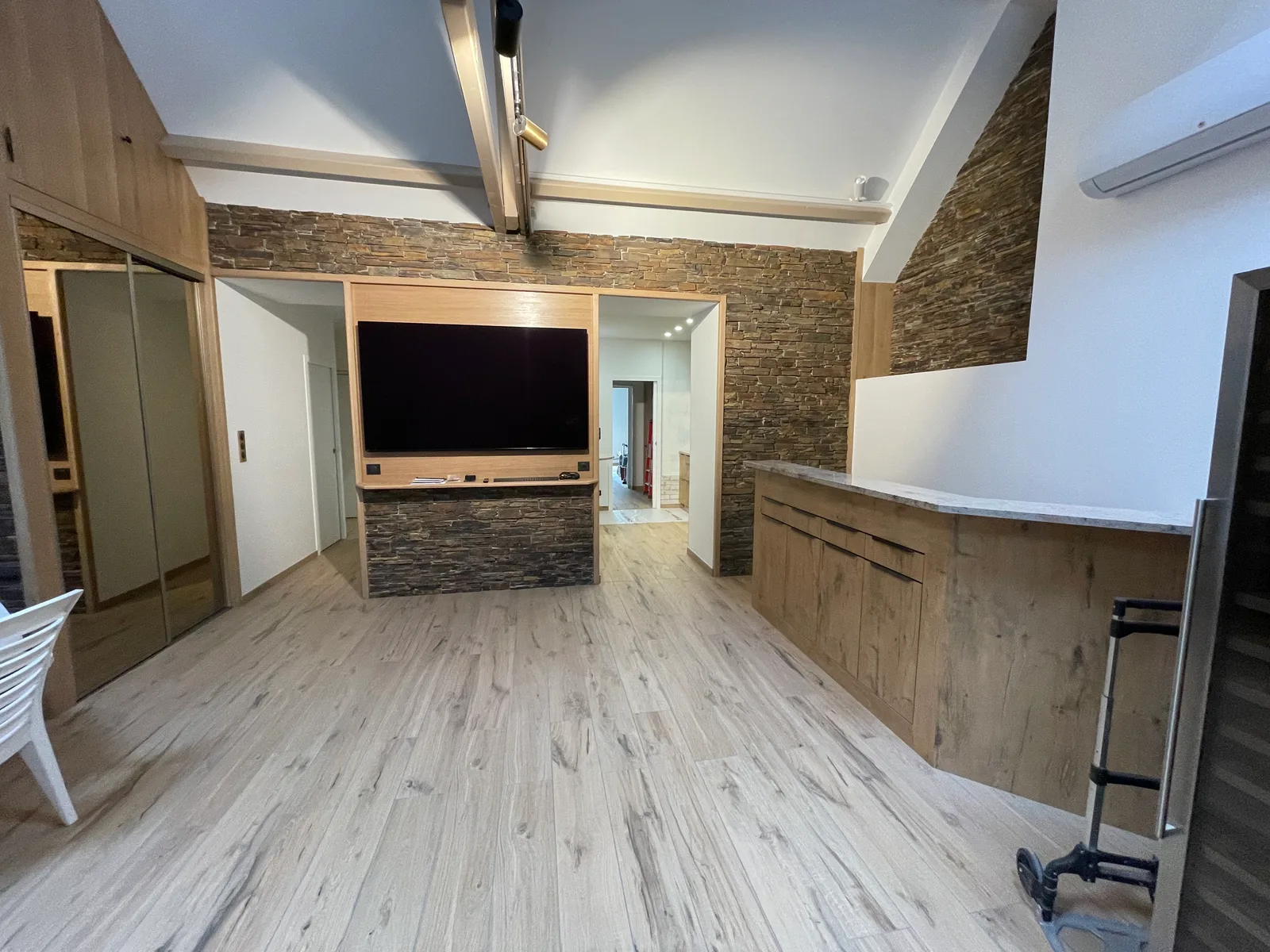 Salon avec mur en pierre et parquet bois — chantier ARPE